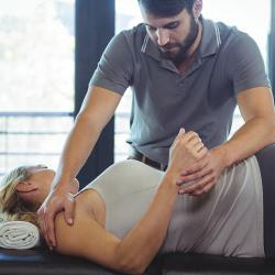 physical therapist helping patient